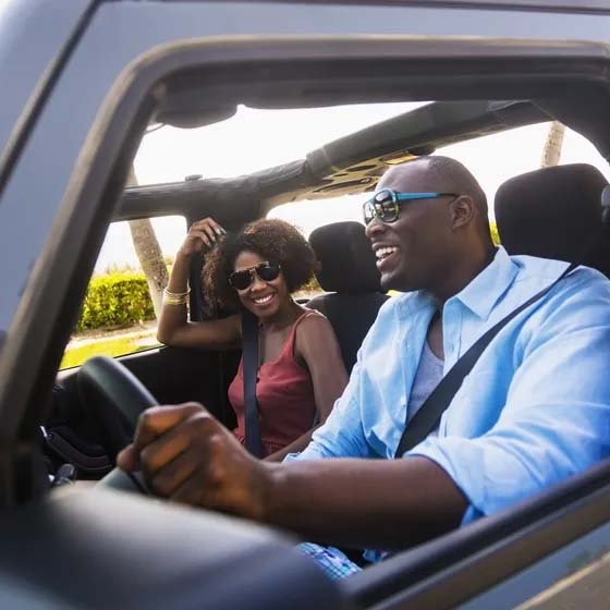 Man and woman driving jeep