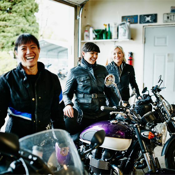 Three women sitting on their motorcycles