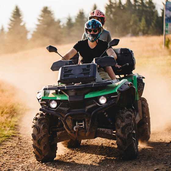 Two people on ATV in dirt