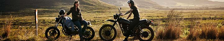 Two people on side of road with motorcycles