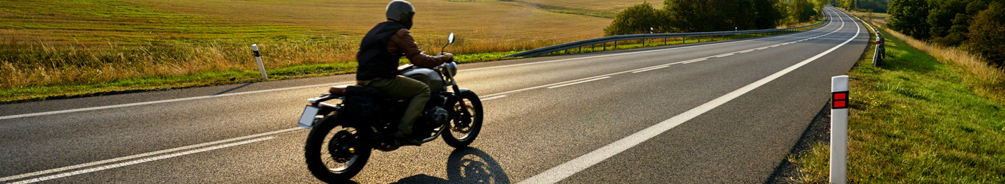Man riding motorcycle down road