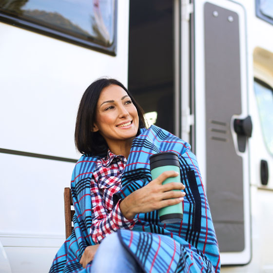 Woman by camper with blanket