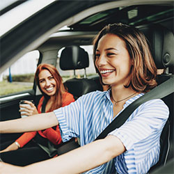 Woman and friend in car smiling