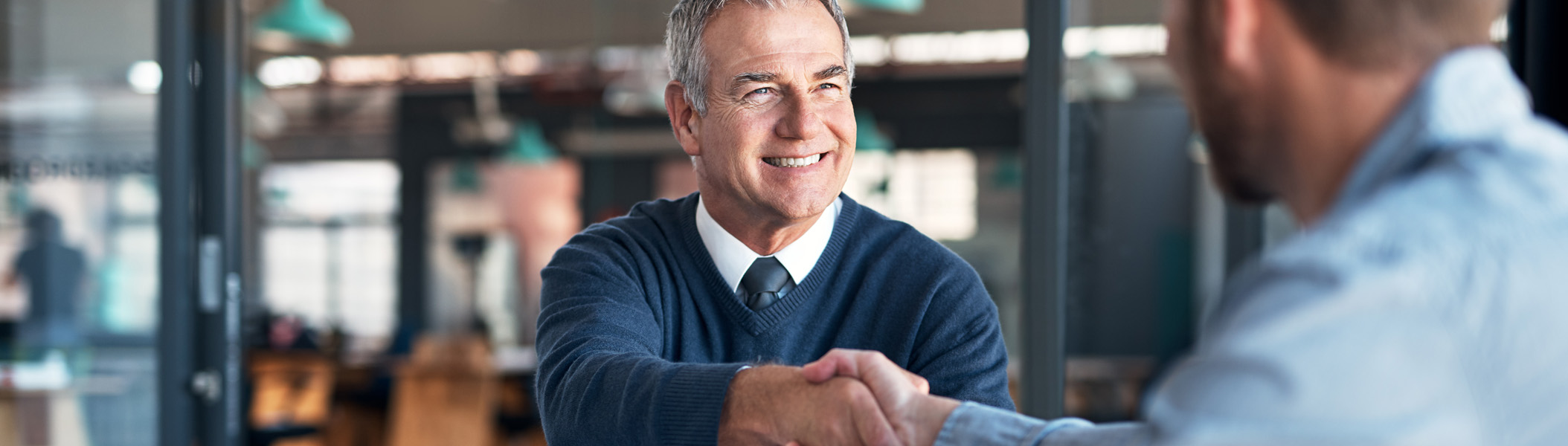 Two men shaking hands in a meeting